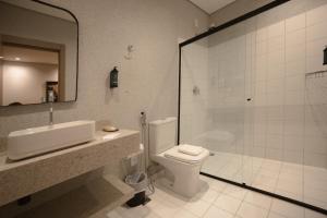 a bathroom with a shower and a toilet and a sink at Village Rio Hotel in Chavantina