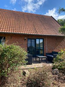a brick house with a couch and a bench at Smeers Hof in Böhme +12 photos