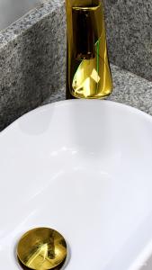 Eine goldene Vase steht auf einer Theke. in der Unterkunft Royale Studio in Criciúma + 36 Fotos