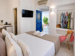 a bedroom with a white bed and a blue door at Mania Rooms and Studios in Poros
