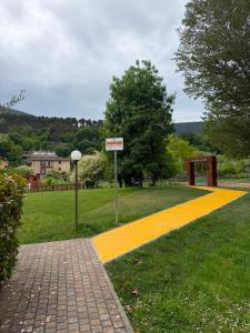 a yellow walkway in a park with a street sign at Riva Bianca in Ameglia