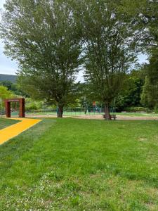 a park with two trees and a yellow sidewalk at Riva Bianca in Ameglia