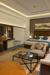 a hotel room with a bed and a coffee table at سراة للشقق الفندقية in Al Namas