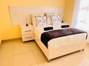 a bedroom with a large bed with two lamps on it at MrP Guest House in Kokstad