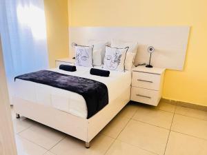a bedroom with a large white bed and a night stand at MrP Guest House in Kokstad