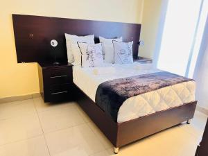 a bedroom with a large bed with a wooden headboard at MrP Guest House in Kokstad