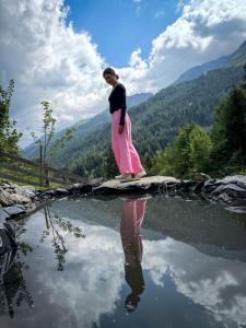 Eine Frau steht auf einem Gewässer. in der Unterkunft TENNE Arlberg - Boutique Hotel & Restaurant in Sankt Anton am Arlberg