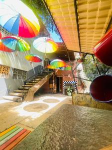 a group of colorful umbrellas hanging from a building at Hotel Sinhá in Tianguá