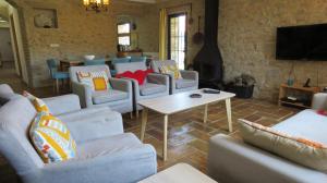 a living room with couches and a table and a tv at Escape to a spacious retreat with garden in Avinyonet de Puigventós +66 photos