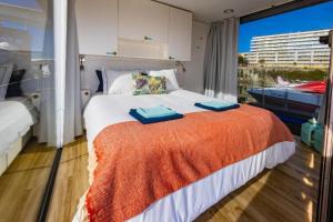 a bedroom with a large bed with an orange blanket at SLEEPBOAT Floating House Boat Oporto Douro in Porto