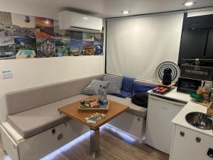 a small living room with a couch and a table at SLEEPBOAT Floating House Boat Oporto Douro in Porto