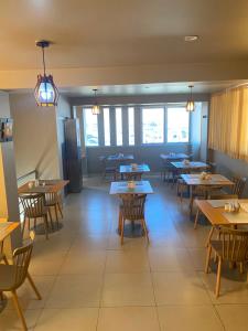 a dining room with tables and chairs and windows at Hotel Dubái in Tacna