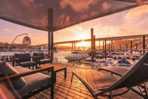 a deck on a yacht with chairs and a boat at SLEEPBOAT Floating House Boat Oporto Douro in Porto