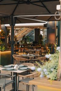 a restaurant with tables and chairs with flowers on them at Laid Hotel in Vlorë
