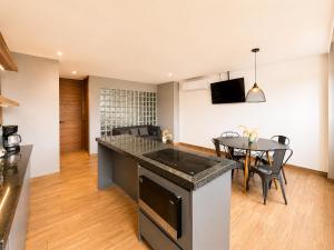 a kitchen and living room with a table and a counter top at Modernos departamentos tipo LOFT a dos calles del estadio in Boca del Río