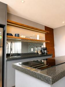 a kitchen with a counter with a stove top oven at Modernos departamentos tipo LOFT a dos calles del estadio in Boca del Río