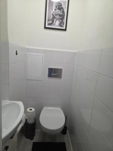 a white bathroom with a toilet and a sink at Apartament cisza i spokój in Toruń +1 photo