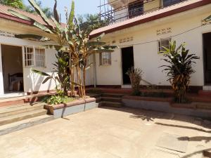 a house with trees and plants in front of it at Manhattan Guesthouse Kampala in Kampala