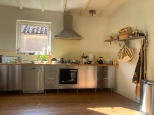 a kitchen with stainless steel appliances and a window at Achter de kerk in Eppenhuizen