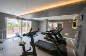 a gym with several treadmills and a row of exercise bikes at Flat em hotel Promenade Itaguaí in Itaguaí +4 photos