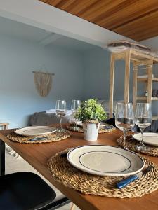 a wooden table with plates and wine glasses on it at Dpto General Roca 1355 - La Loggia in San Martín de los Andes +12 photos