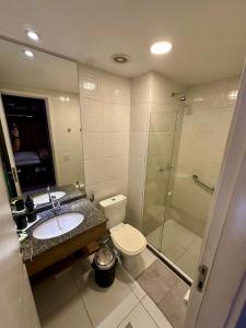 a bathroom with a toilet and a sink and a shower at Flat em hotel Promenade Itaguaí in Itaguaí