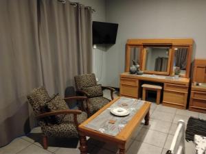 a living room with a table and chairs and a mirror at Wildebeespan Guest Farm in Delareyville