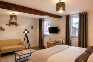 a bedroom with a bed and a couch and a television at Boutique Hotel Marielle in Bad Münstereifel