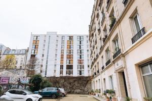 a street with cars parked in front of buildings at Chic Studio Apartment for 3 - La Villette! in Paris