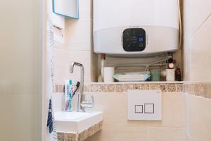 a bathroom with a sink and a hair dryer at Chic Studio Apartment for 3 - La Villette! in Paris