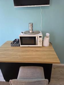a microwave sitting on top of a wooden table at Les Perriers in Chambray-lès-Tours