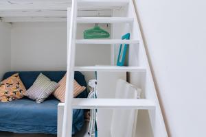 a white bunk bed with a blue couch in a room at Chic Studio Apartment for 3 - La Villette! in Paris +7 photos