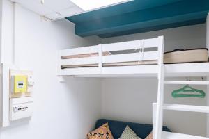 a bunk bed in a room with a couch at Chic Studio Apartment for 3 - La Villette! in Paris