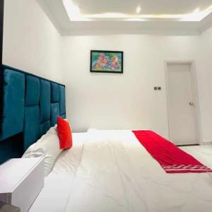 a bedroom with a large white bed with a red blanket at MyTime Hotel in Tamale