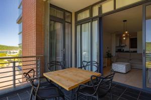 a patio with a wooden table and chairs on a balcony at Azure Guesthouse in Ballito