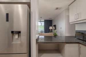 a kitchen with a stainless steel refrigerator in a room at Azure Guesthouse in Ballito +9 photos