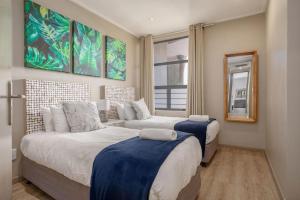 a bedroom with two beds and a couch at Azure Guesthouse in Ballito