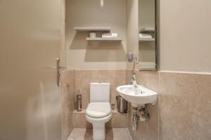 a bathroom with a toilet and a sink at Azure Guesthouse in Ballito