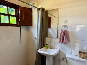 a bathroom with a sink and a toilet and a mirror at Atelier-Aconchego e Fitness in Pirenópolis +17 photos