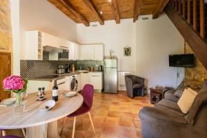 a kitchen and living room with a table and chairs at La Tour Aliénor, maison de caractère du XIVème siècle in Beynac-et-Cazenac