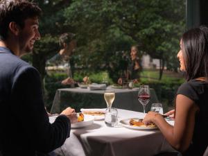 a man and woman sitting at a table eating food at Pullman Sydney Hyde Park in Sydney