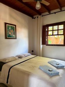 a bedroom with a bed with two towels on it at Atelier-Aconchego e Fitness in Pirenópolis