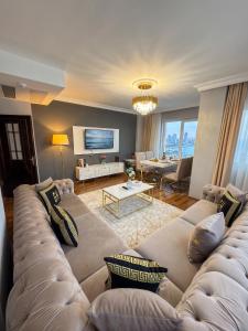 a living room with a large couch and a table at Golden Homes in Bostancı