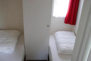 a small room with two beds and a window at Chalet nr 43 in Molkwerum