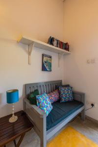 a bed in a room with a shelf and pillows at Old Chilli House in Unawatuna