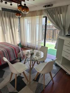 a bedroom with a table and chairs and a bed at Alojamientos Quintamar Viña in Viña del Mar