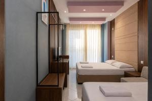 a hotel room with two beds and a mirror at AMMEN Rooms in Shëngjin