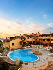 a resort with a large swimming pool and some buildings at Residence Borgo Punta Villa in La Maddalena