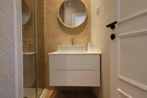 a bathroom with a white sink and a mirror at Tinico's Guest Rooms in Nazaré +30 photos
