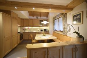 a kitchen with wooden cabinets and a table in it at Romantic Chalet Dolomiti in Val di Zoldo